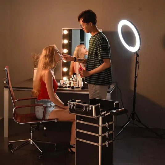 Neceser profesional 4 niveles con llantas. Maquillador trabajando en estudio de belleza con el neceser desplegable de 4 niveles junto al aro de luz.