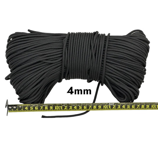 Piola cuerda de polipropileno negra.  Vista superior de madeja de un kilogramo piola cuerda de polipropileno negra de 4 milímetros de grosor, con regla métrica de medición visible.